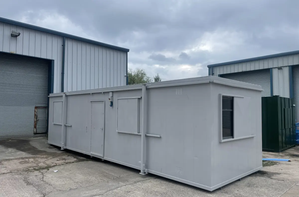 Used portable cabin being assessed in a yard with the door open and floor visible