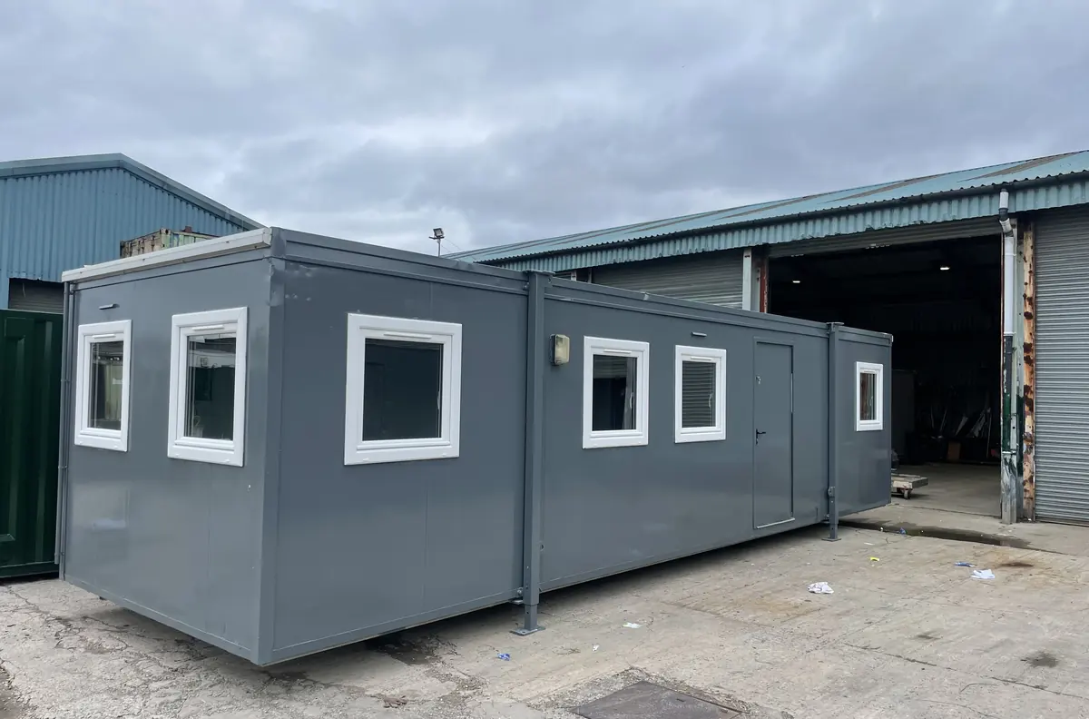 Row of used portable cabins standing in a storage yard awaiting refurbishment