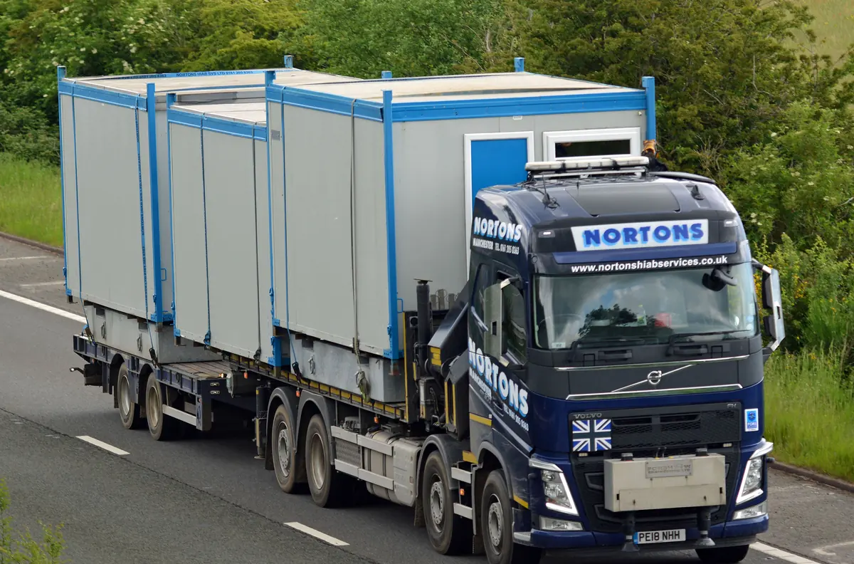 Hiab lorry carrying two portable cabins on the motorway in mainland Britain